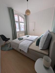 a bedroom with a bed and a chair and a window at Appartement Napoleon in Meißen