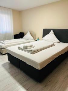 two beds in a hotel room with towels on them at Carla Maria S Hause in Gammertingen