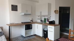 a kitchen with white cabinets and a wooden counter top at Appartements simples et fonctionnels in Pamiers