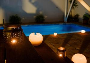 a swimming pool with lights and a table with candles at miKasa Agua Amarga & SPA in Agua Amarga