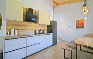 a kitchen with white cabinets and a wooden table at Nice Home In Licka Jesenica With Sauna in Lička Jesenica
