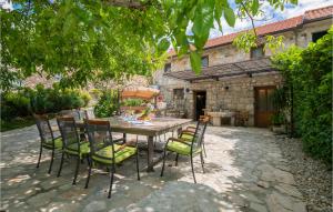a table and chairs in front of a house at Holiday Home Zmijavci I in Zmijavci