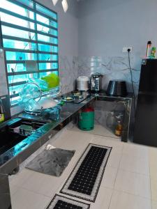 a kitchen with a counter top with a counter top at Homestay Lyn Impian in Tanjung Rambutan +10 photos