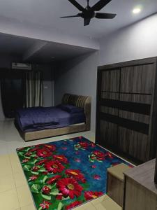 a bedroom with a bed and a flower rug at Homestay Lyn Impian in Tanjung Rambutan