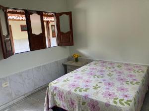 a bedroom with a bed with a floral bedspread at Rancho 7 maravilha in Bonito