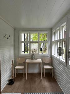 a room with a table and two chairs and windows at Vääksyn Mummola in Vääksy