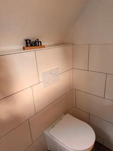 a bathroom with a toilet and a shelf with the word faith at Ruhrtraum Kettwig Ferienwohnung am Fluss in Essen