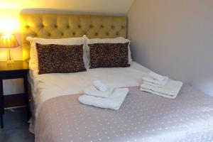a bed with two towels and two pillows on it at George Mine Barn, Bolehill, in the Peak District in Wirksworth +9 photos