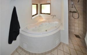 a white bath tub in a bathroom with a window at Holiday Home Hyldevej Ebeltoft Vi in Øksenmølle +29 photos