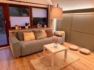 a living room with a couch and a table at Ruhrtraum Kettwig Ferienwohnung am Fluss in Essen +4 photos