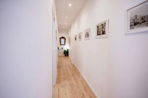 a hallway with white walls and a wooden floor at Politeama Charming Apartment in Palermo