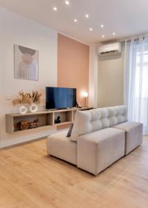 a living room with a white couch and a flat screen tv at Politeama Charming Apartment in Palermo