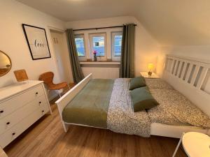 a bedroom with a bed and a dresser and a window at Ruhrtraum Kettwig Ferienwohnung am Fluss in Essen
