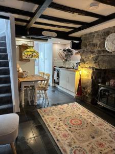 a kitchen with a table and a dining room at Love Lane Cottage Dolgellau in Dolgellau