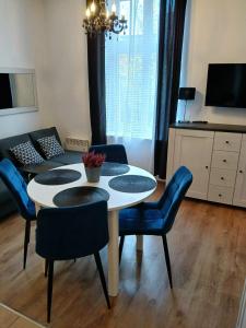a dining room with a table and blue chairs at Beachfront apartment Sopot in Sopot +15 photos