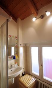 uma casa de banho com um lavatório e 2 janelas em B&B Casa al Mulino em Cannero Riviera