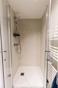 una ducha con puerta de cristal en un baño en Au jardin Ginkgo, en Quimper