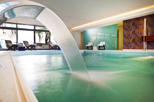 una piscina con una fuente de agua en una habitación de hotel en Pliadon Gi Mountain Resort & Spa en Kato Trikala Korinthias