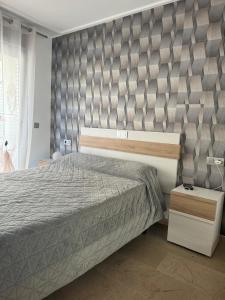 a bedroom with a large bed with a gray headboard at Holiday Marina D'or in Oropesa del Mar