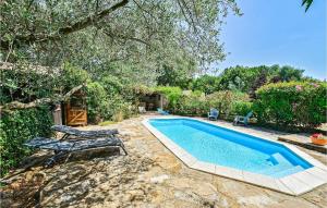 a swimming pool with two lounge chairs next to it at Les Oliviers in Vinezac
