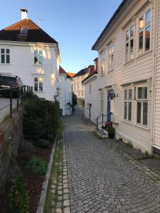 une rue pavée dans une ville avec des bâtiments blancs dans l'établissement Studio above Bryggen with local charm, à Bergen
