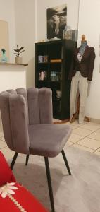 une chaise brune dans une pièce avec mannequin dans l'établissement Studio cosy Bassens 33530, à Bassens