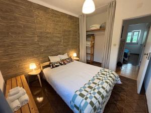 サン・ルイスにあるCasa do Henriqueのベッドと木の壁がある寝室