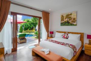 a bedroom with a bed and a view of a pool at Delight ART Villas in Seminyak