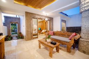 a living room with a couch and a table at Abitama Villa in Ubud