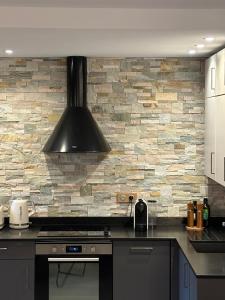 eine Küche mit einem Herd und einer Steinmauer in der Unterkunft Arc1950 Prince Des Cimes appt 4-5 pers ski in out piscine intérieure in Arc 1950