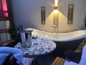 ein Badezimmer mit Badewanne und einem Tisch vor der Badewanne in der Unterkunft Bath Lane Cottages & Sauna Garden x8 beds in Newcastle + 34 Fotos