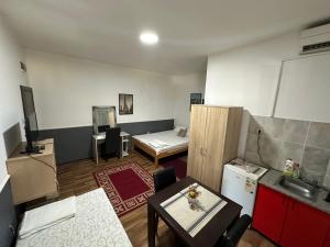 a room with two beds and a table and a kitchen at Apartments Agape in Belgrade