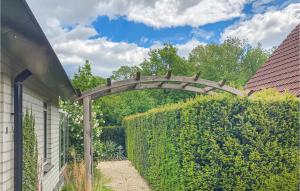 een houten boog over een heg in een tuin bij Residentie De Mors Type Dinkel in Delden