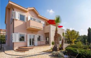 a house with a palm tree in front of it at Awesome Apartment In Barbat-Rab in Barbat na Rabu