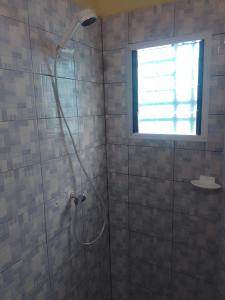 JacquevilleにあるWelcome Hôtelの窓のある浴室のシャワー