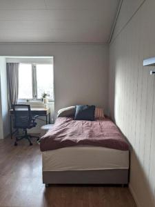 a bedroom with a bed and a desk and a chair at Haugesund City Apartments in Haugesund
