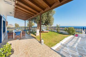 a patio with a table and a view of the ocean at Stegna House Sea View in Archangelos