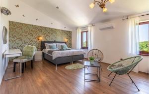 a bedroom with a bed and chairs in a room at Lovely Home In Loborika in Loborika