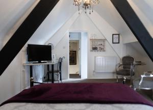 a bedroom with a bed and a desk with a television at Longbridge House in Shepton Mallet