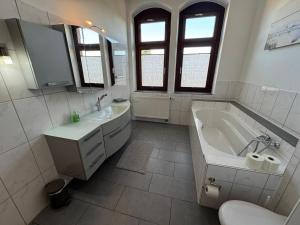 a white bathroom with a tub and a sink at Posthaus22 Wohnung OG in Salzgitter +15 photos