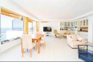 a living room with a table and chairs at Penthouse Montemarina primera línea Anfi del Mar in Mogán