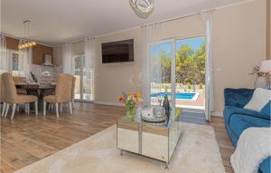 a living room with a blue couch and a table at 3 Bedroom Gorgeous Home In Jadrtovac in Jadrtovac