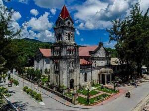 an old building with a clock tower on a street at Sea Me in Kansaloay