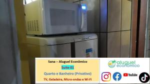 a microwave sitting on top of a refrigerator at Sana - Aluguel Econômico in Sana