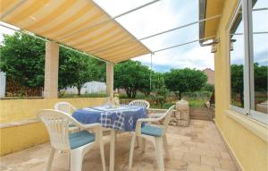 a table and chairs on a patio with glass doors at Two-Bedroom Apartment In Racisce in Račišće