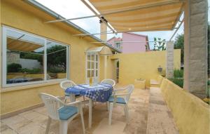 a patio with a table and chairs and a window at Two-Bedroom Apartment In Racisce in Račišće +28 photos