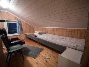 a bedroom with a bed and a chair in a room at Hansali Holiday Home in Fjarland