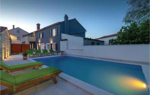 a swimming pool with green chairs and a house at Cozy Home In Hreljici in Hreljići