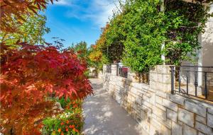 a stone wall with plants and flowers on it at Gorgeous Apartment In Rabac With Wifi in Rabac