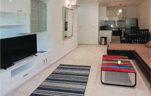 a living room with a flat screen tv and a stool at Two-Bedroom Apartment In Ston in Ston